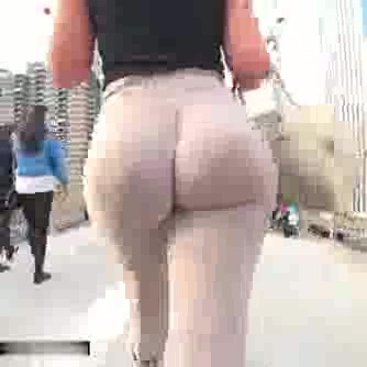 Rabuda calça colada andando na rua
