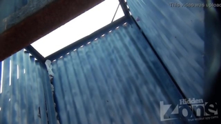 Câmera escondida em uma cabana de praia. Loira bronzeada de shorts jeans